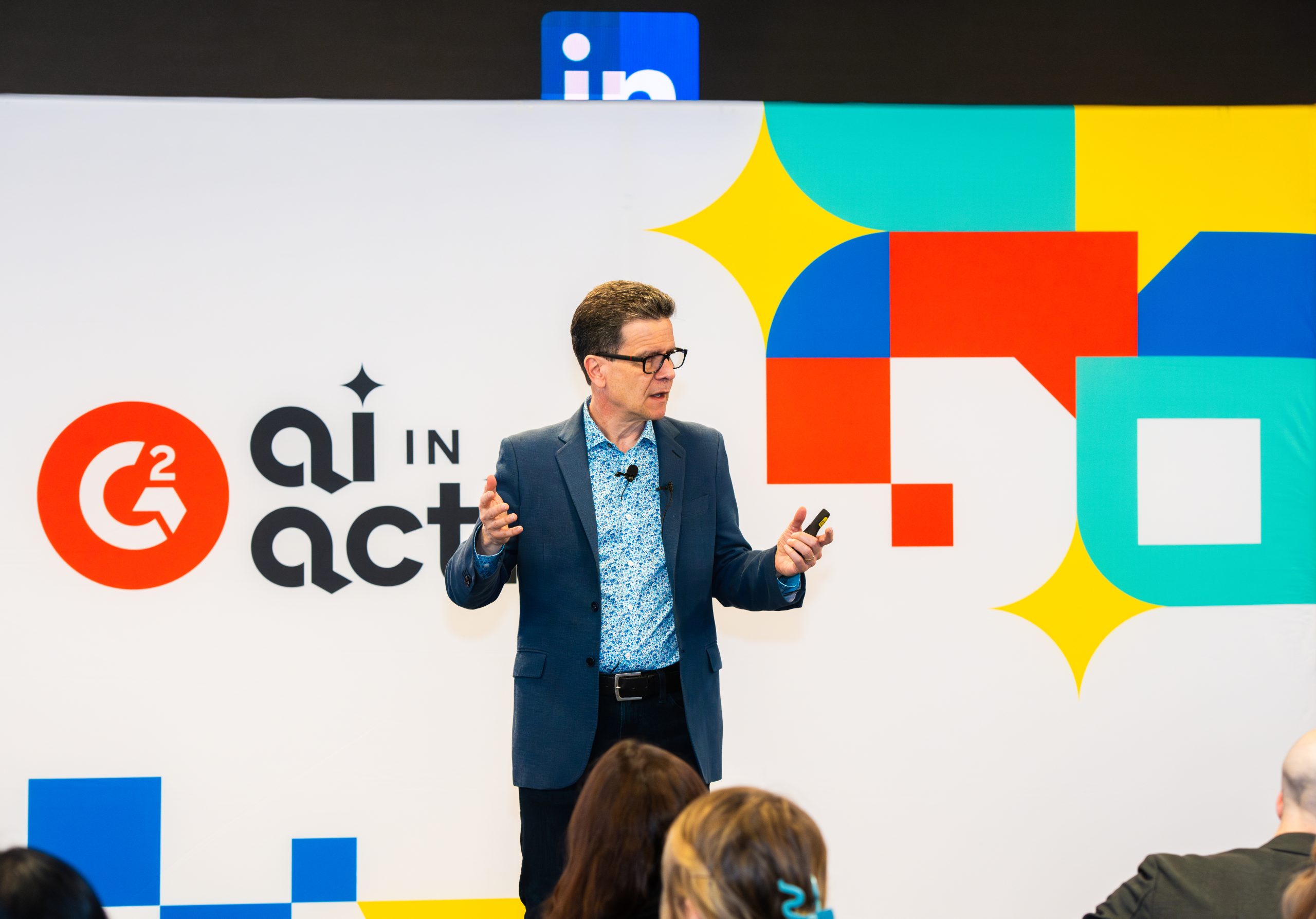 Tim Sanders speaking onstage in front of an AI in Action backdrop.
