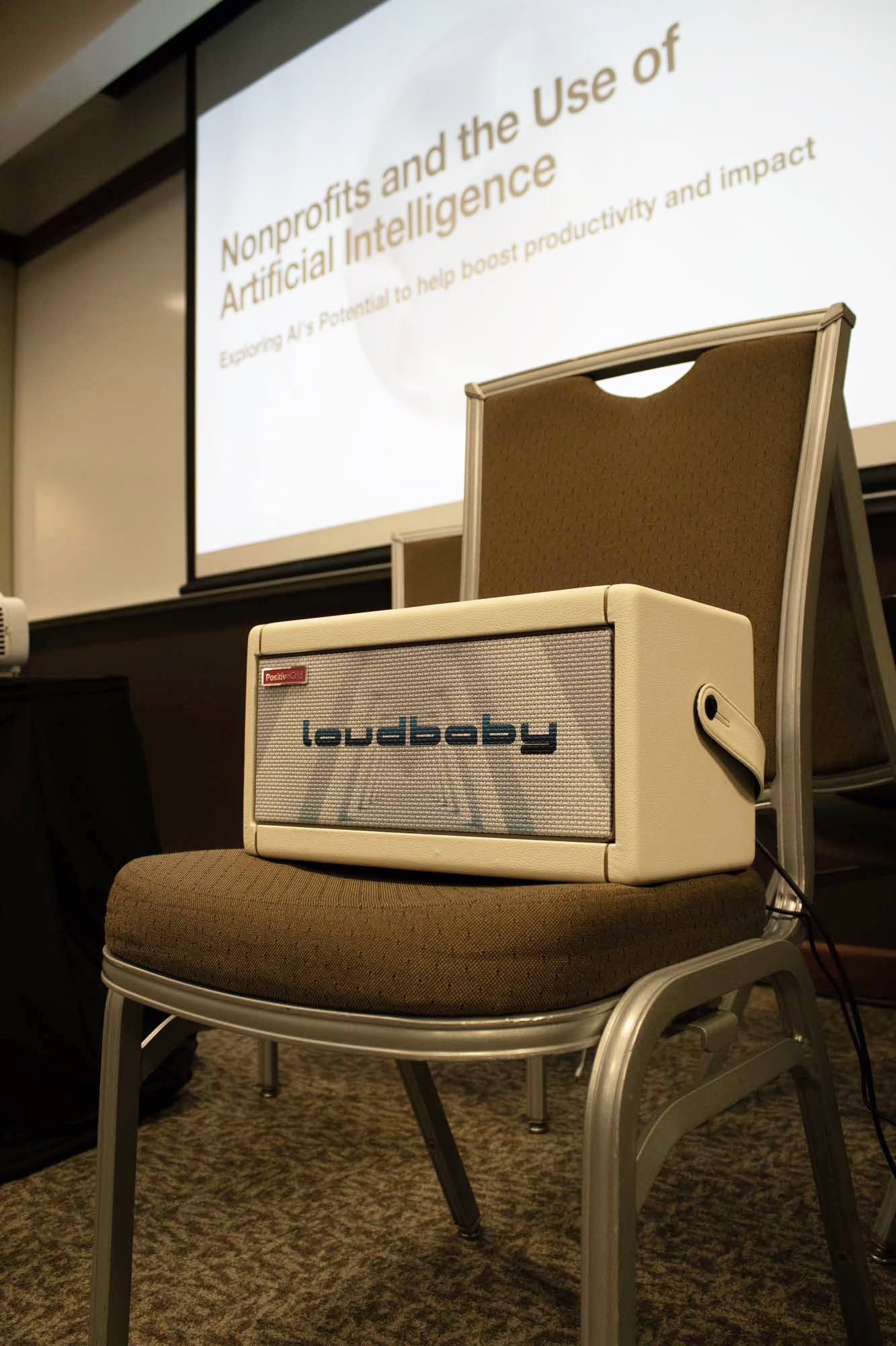 Loudbaby branded amplifier beneath the AI for nonprofits presentation screen
