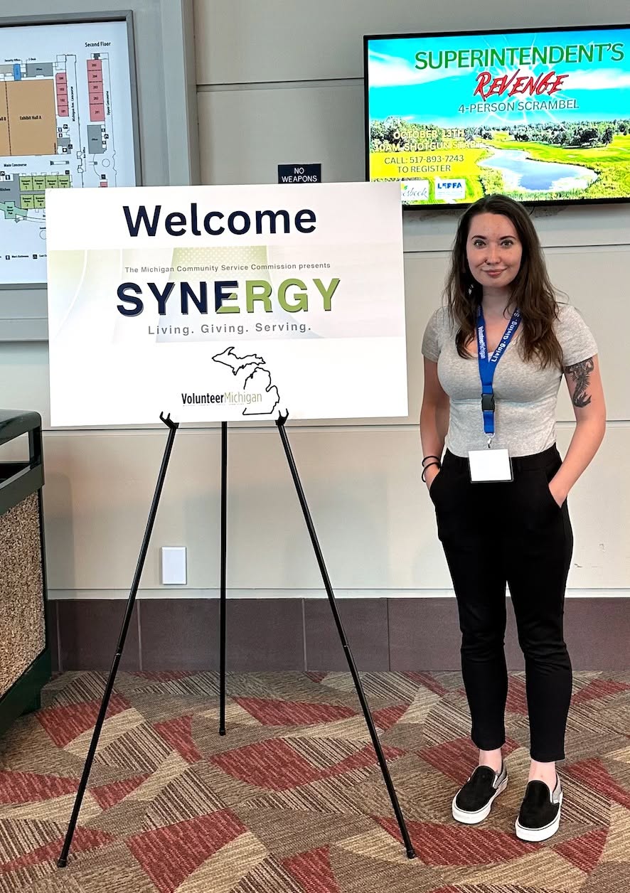 Loudbaby’s Kait Fore beside the Synergy welcome sign